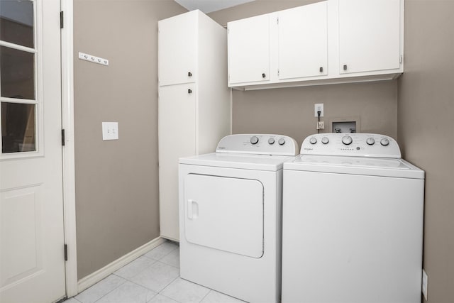 laundry room with light tile patterned flooring, cabinet space, baseboards, and separate washer and dryer