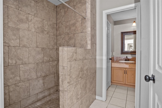 full bathroom featuring tile patterned floors, tiled shower, and vanity