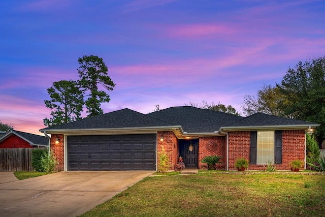 ranch-style home featuring a garage, brick siding, driveway, and a lawn