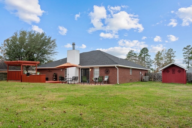 back of property featuring an outbuilding, brick siding, a lawn, and a shed