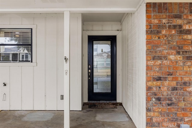 view of exterior entry with brick siding