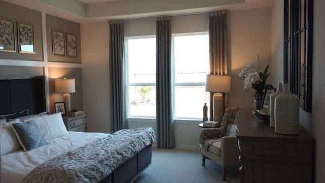 bedroom featuring light carpet and baseboards