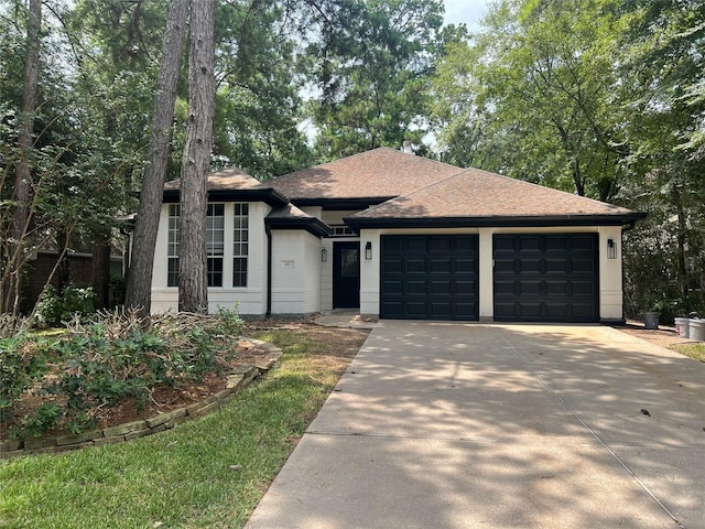 view of front facade featuring a garage, concrete driveway, and a shingled roof