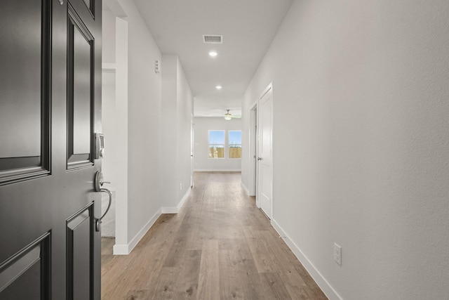 hallway featuring visible vents, recessed lighting, light wood-style floors, and baseboards