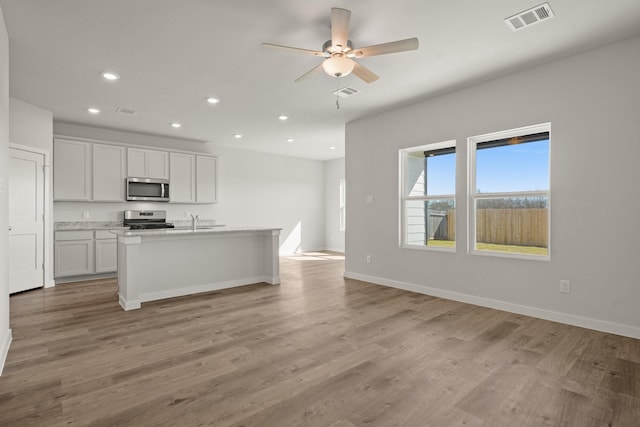 kitchen with visible vents, light wood-type flooring, recessed lighting, stainless steel appliances, and open floor plan