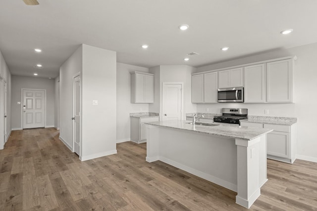 kitchen featuring recessed lighting, stainless steel appliances, light wood-style floors, and a sink