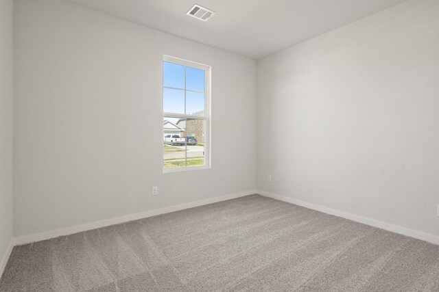 unfurnished room with visible vents, baseboards, and carpet