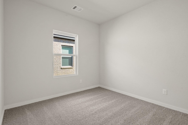 empty room with carpet flooring, baseboards, and visible vents