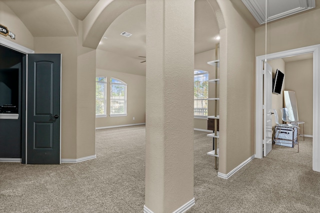 corridor featuring light carpet, arched walkways, and attic access