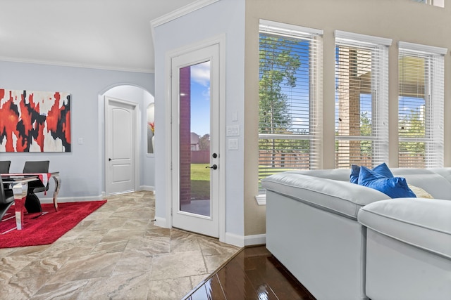 doorway featuring ornamental molding, arched walkways, and baseboards