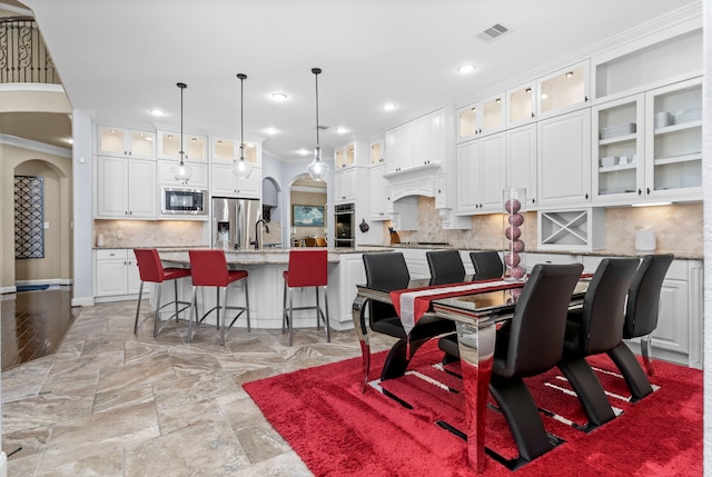 dining space featuring arched walkways, visible vents, and recessed lighting