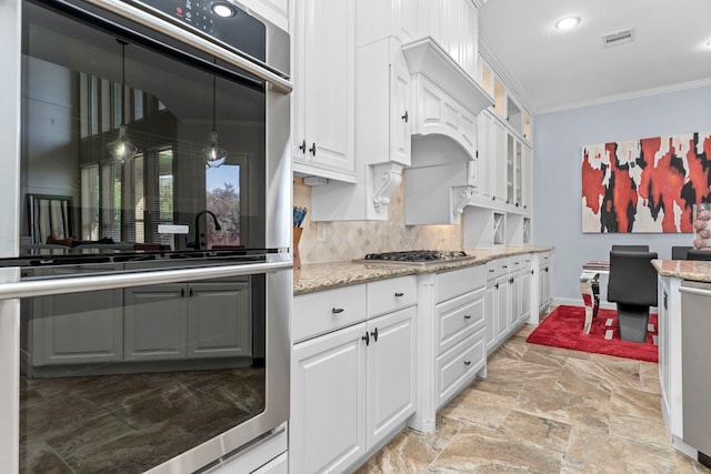 kitchen featuring ornamental molding, appliances with stainless steel finishes, white cabinetry, and pendant lighting