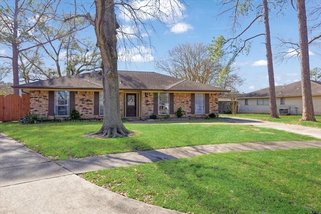 single story home featuring fence, a front lawn, and brick siding