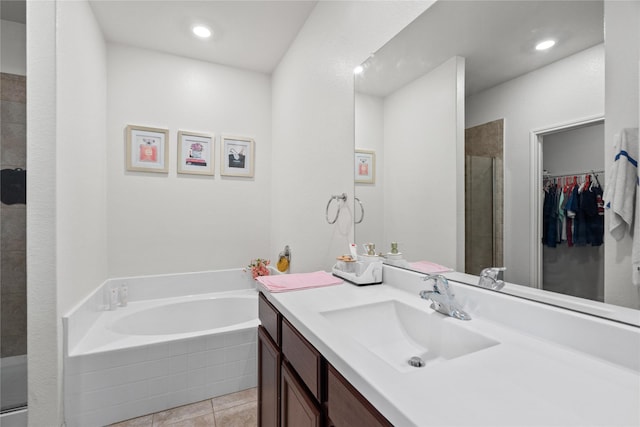 bathroom featuring a stall shower, tile patterned floors, a spacious closet, vanity, and a bath