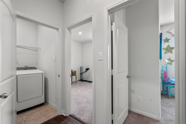 washroom featuring laundry area, baseboards, washer / clothes dryer, and light colored carpet