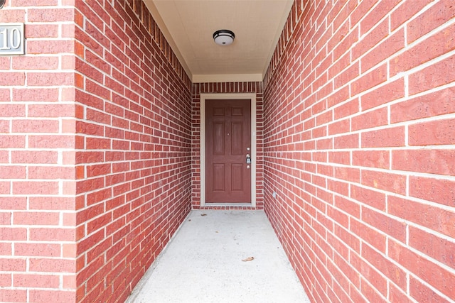 entrance to property featuring brick siding