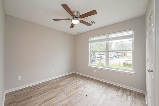 unfurnished room featuring a healthy amount of sunlight, light wood finished floors, and baseboards