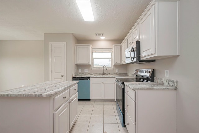 kitchen featuring stainless steel appliances, light countertops, white cabinetry, and a sink