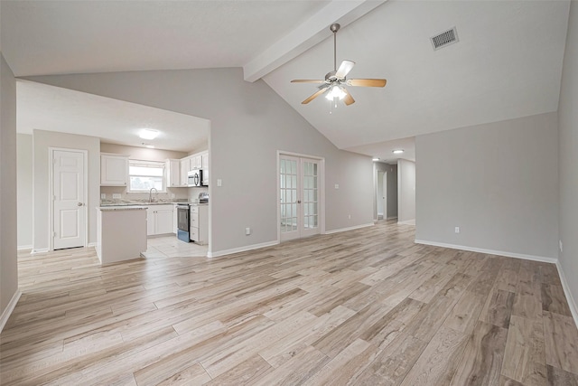 unfurnished living room featuring a ceiling fan, beam ceiling, visible vents, and light wood-style flooring