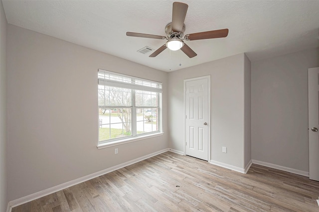 unfurnished bedroom with light wood finished floors, a closet, visible vents, ceiling fan, and baseboards