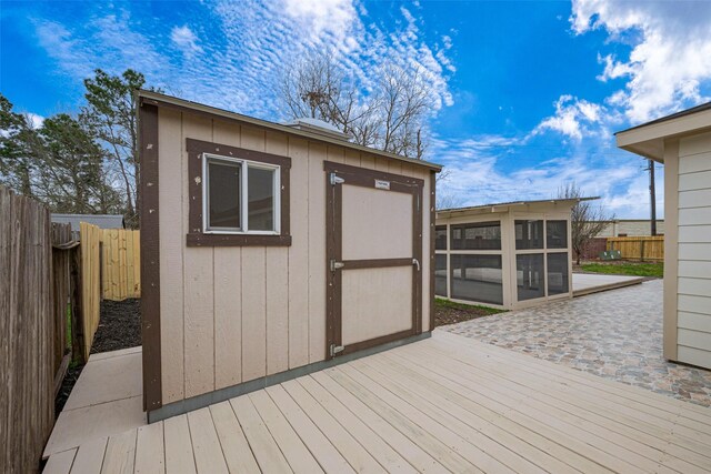 view of shed with a fenced backyard and a sunroom