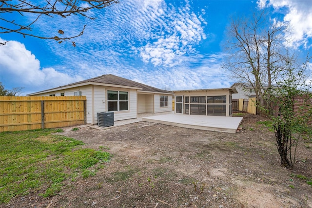 rear view of property with a sunroom, central AC, a patio, and a fenced backyard