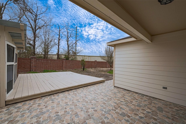 wooden deck featuring a fenced backyard and a patio