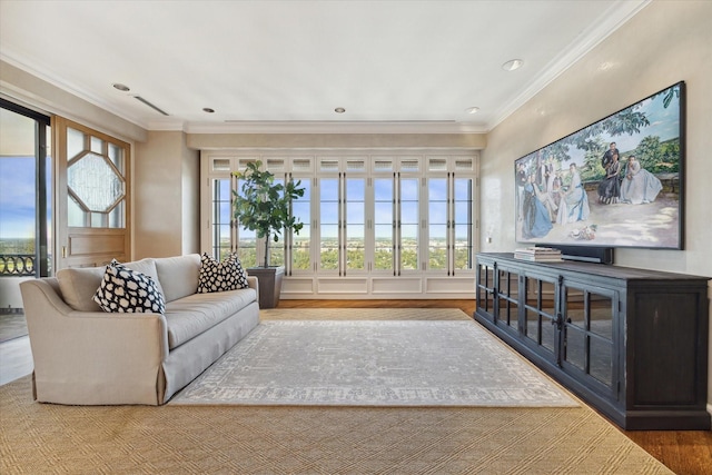 living room with visible vents, crown molding, and wood finished floors