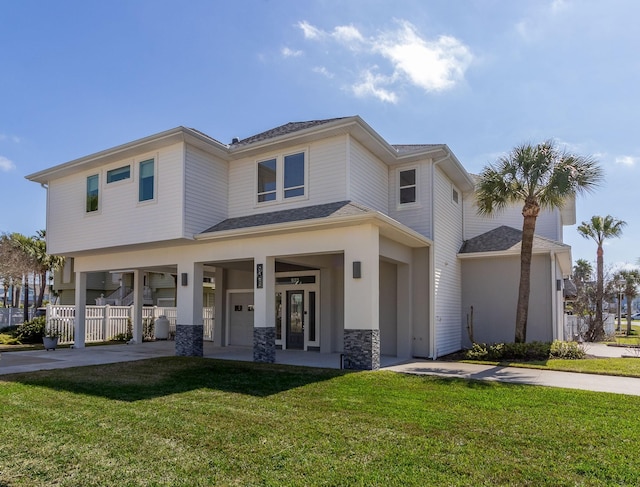 view of front of home with stone siding, a front yard, a carport, and driveway