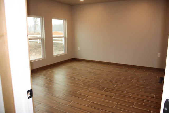 unfurnished room with wood finish floors and baseboards