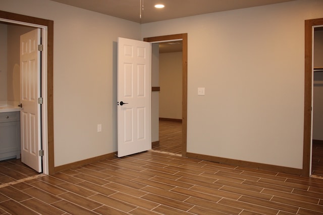 unfurnished bedroom with wood finish floors, recessed lighting, and baseboards