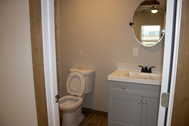 bathroom with toilet, a ceiling fan, wood tiled floor, vanity, and baseboards