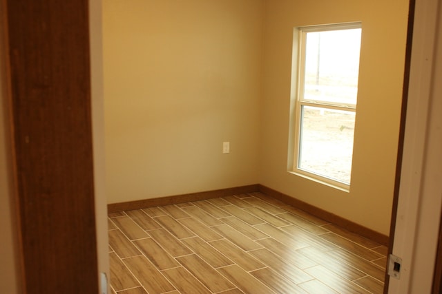 spare room with wood tiled floor and baseboards