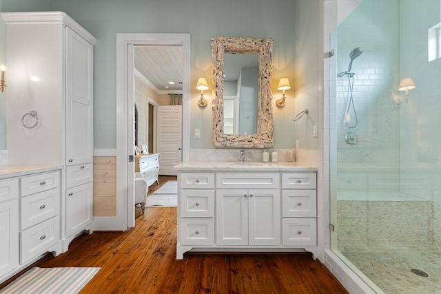 full bath featuring a closet, wood finished floors, vanity, and a stall shower