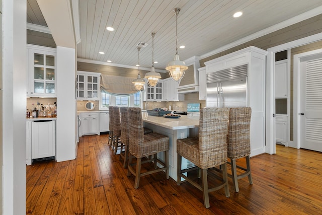 dining area with dark wood-type flooring, recessed lighting, wooden ceiling, and ornamental molding