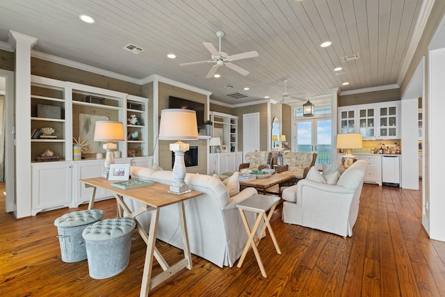 living area featuring wood ceiling, a fireplace, visible vents, and ornamental molding