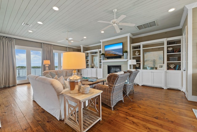 living room with wood ceiling, visible vents, crown molding, and wood finished floors