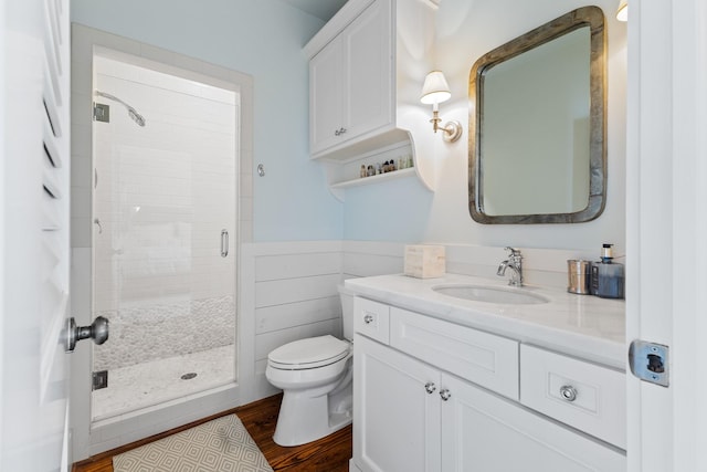 bathroom featuring a stall shower, vanity, toilet, and wood finished floors