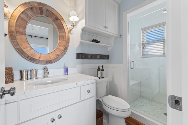 full bathroom featuring a stall shower, vanity, and toilet