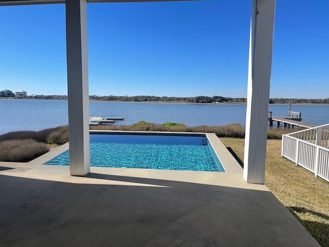 view of pool featuring a water view, a boat dock, fence, and a patio