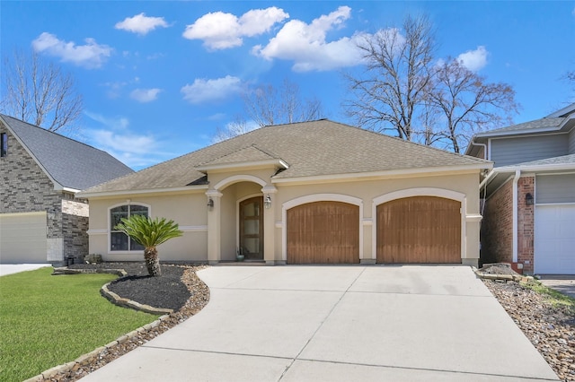 view of front of home with an attached garage, driveway, a front lawn, and stucco siding