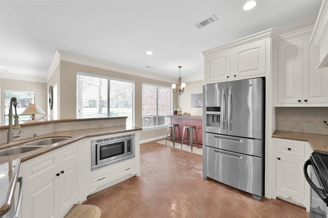 kitchen with a wealth of natural light, appliances with stainless steel finishes, a sink, and visible vents