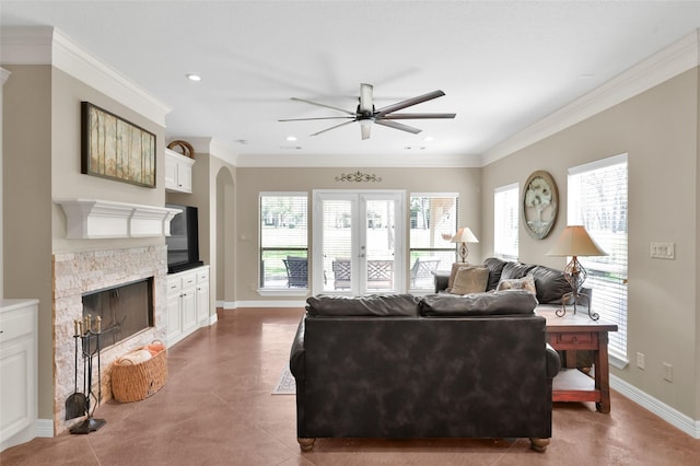 tiled living area with baseboards, ornamental molding, french doors, and a stone fireplace