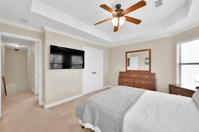 bedroom with light carpet, a tray ceiling, visible vents, and baseboards