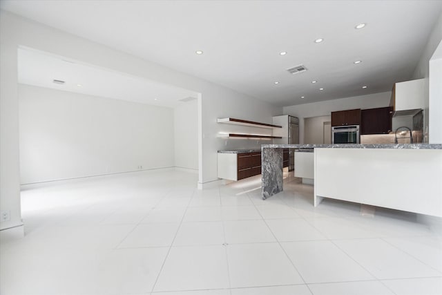 kitchen with visible vents, modern cabinets, oven, light countertops, and a sink