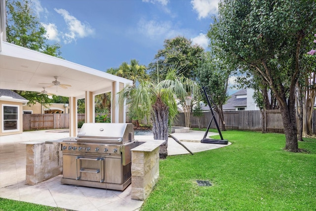 view of yard featuring a patio, exterior kitchen, a fenced backyard, and a ceiling fan