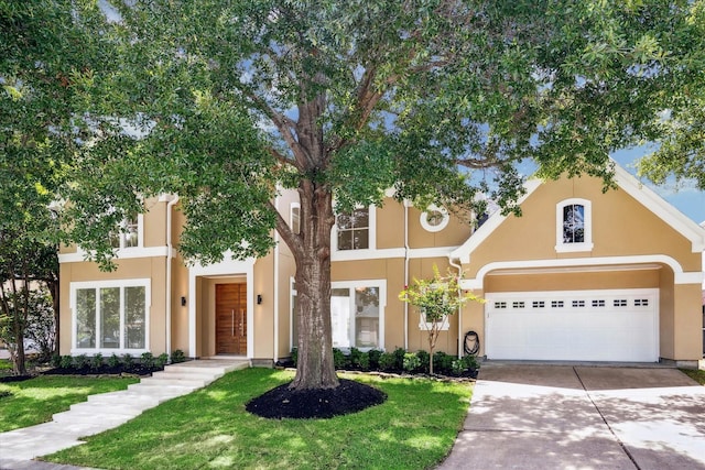 view of front of home featuring concrete driveway, a front lawn, and stucco siding