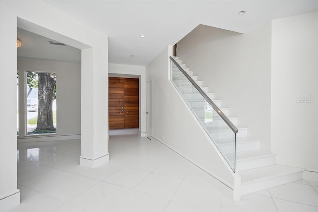 staircase featuring baseboards, tile patterned flooring, visible vents, and recessed lighting