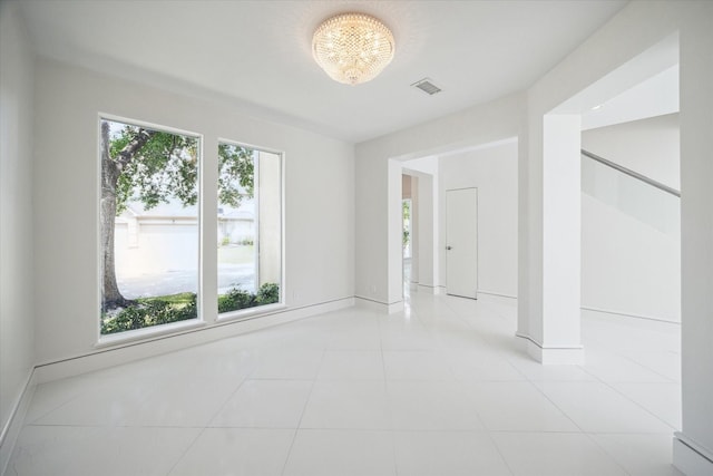 unfurnished room featuring light tile patterned floors, plenty of natural light, and visible vents