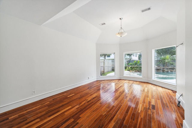 unfurnished room featuring visible vents, baseboards, and wood finished floors